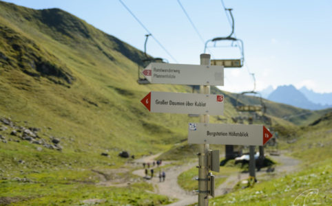 Schilder für Wanderwege und Gondeln der Sesselbahn nahe der Station Höfratsblick am Nebelhorn