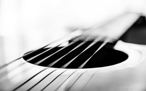 Schwarzweiß Aufnahme eines Schallochs mit den Saiten einer Gitarre als Fineart