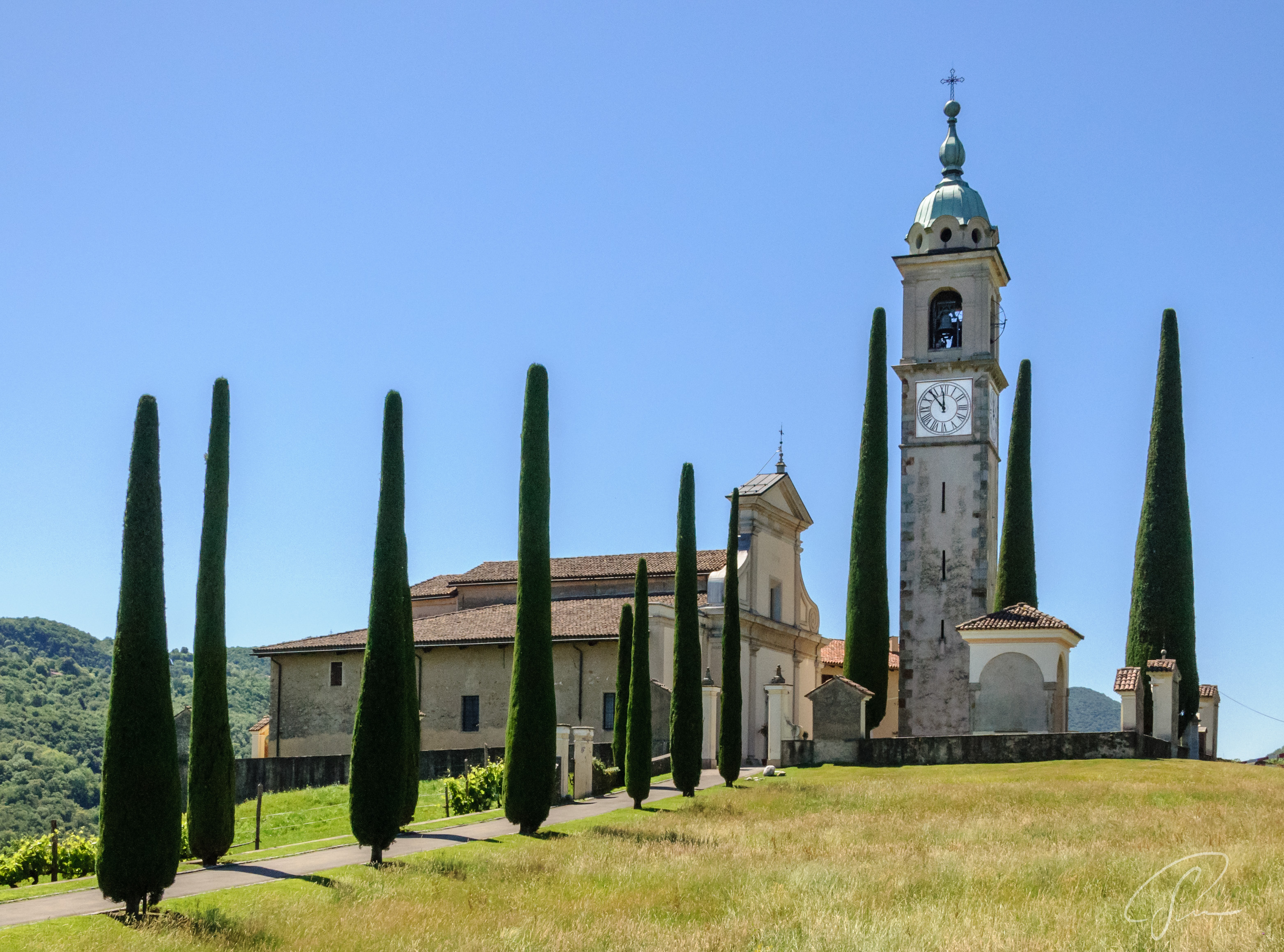 Kirche St Abbondio in Montagnola, eingerahmt von Zypressen