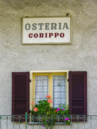 Schild Osteria Corippo über einem Fenster im Valle Verzasca