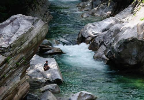 Angler auf den Felsen am Ufer des grünen Verzasca Fluß